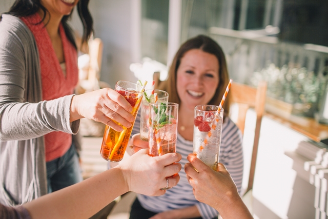 several people clinking different drinks together