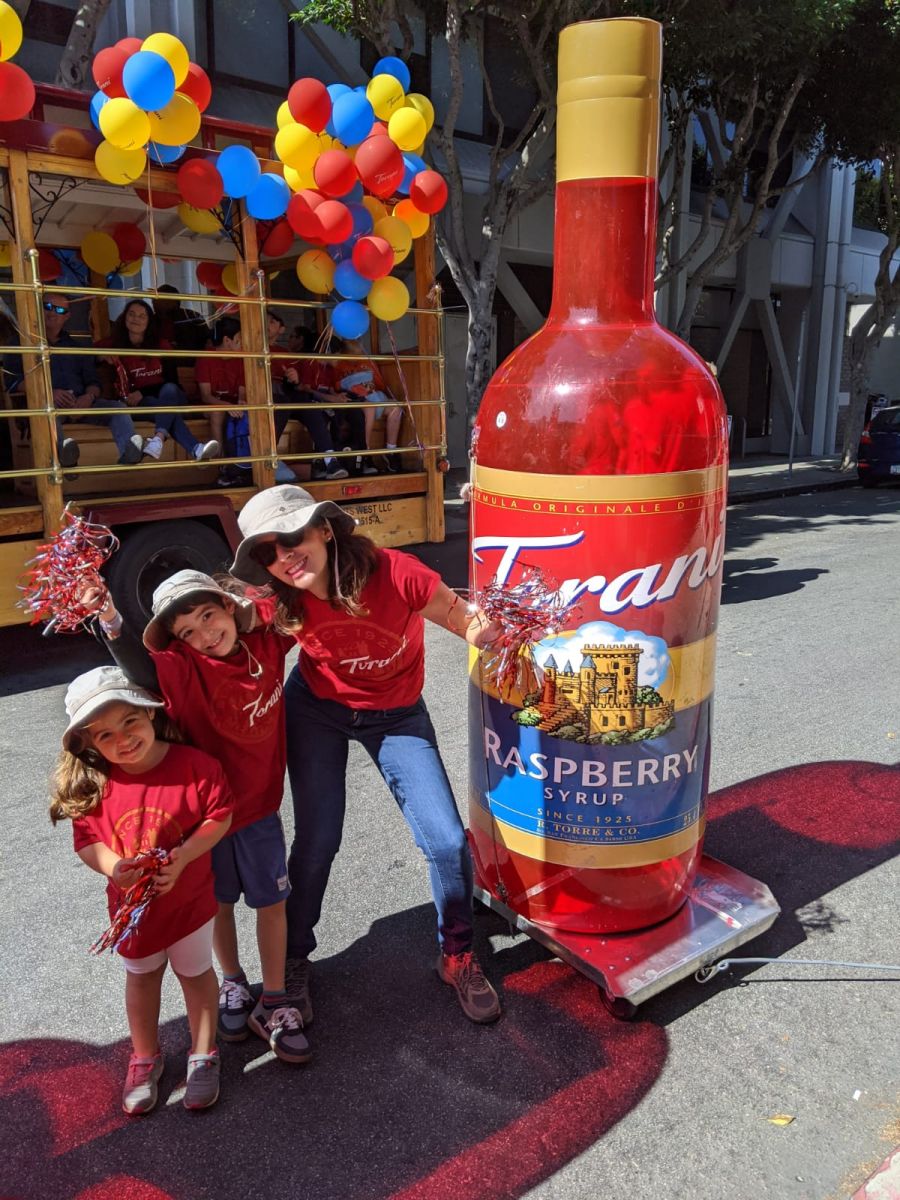 romi with children and very tall bottle of raspberry syrup