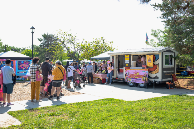 People lining up for a food truck at the park